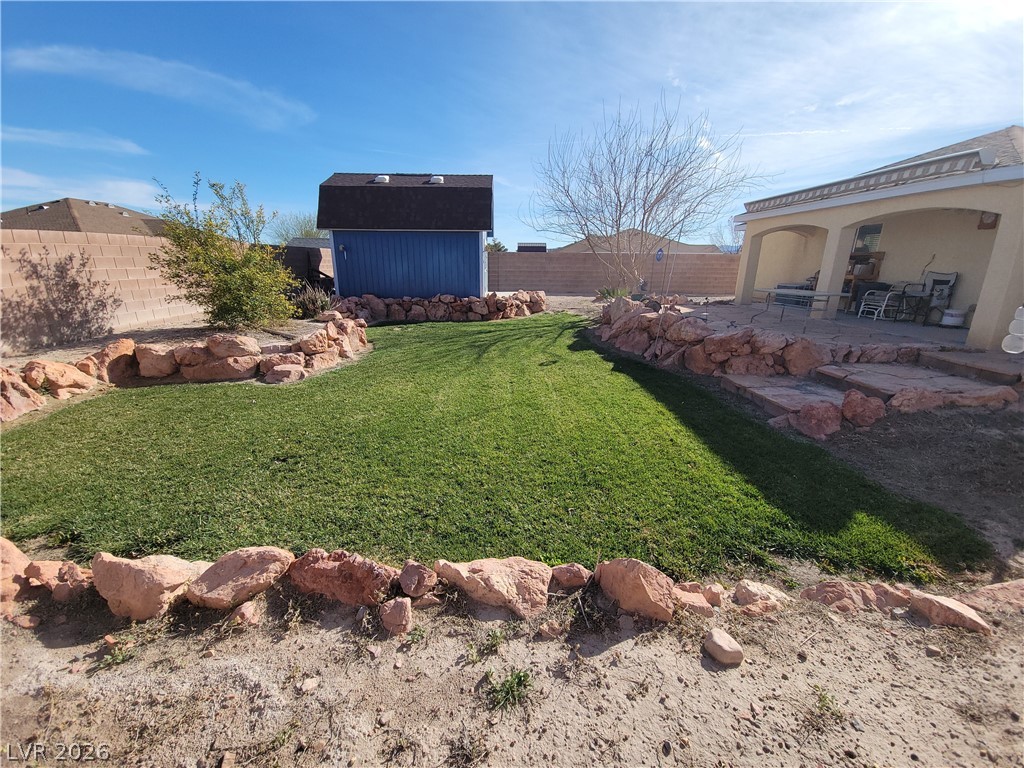 768 Weiser Ridge Street Overton, NV 89040 - Photo 31 of 37 Fenced backyard featuring a storage unit, a patio area, and a garden pond