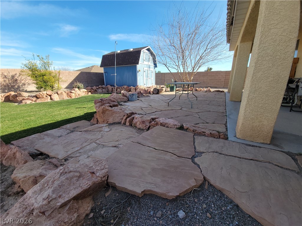 768 Weiser Ridge Street Overton, NV 89040 - Photo 32 of 37 Fenced backyard featuring a storage shed, a patio area, and outdoor dining area