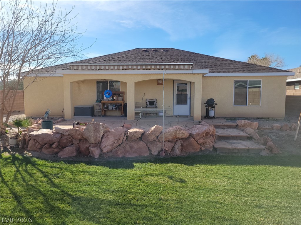 768 Weiser Ridge Street Overton, NV 89040 - Photo 36 of 37 Back of property with a 20'x6' patio, stucco siding, and a lawn