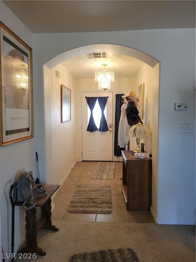 768 Weiser Ridge Street Overton, NV 89040 - Photo 5 of 37 Foyer entrance with arched walkways, a chandelier, and tile patterned floors