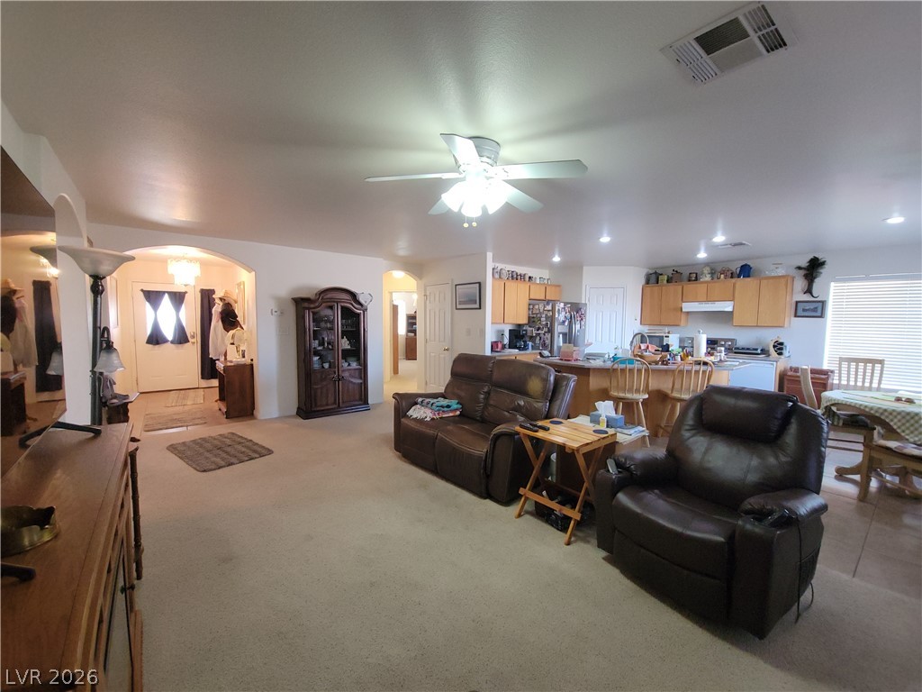 768 Weiser Ridge Street Overton, NV 89040 - Photo 7 of 37 Living room featuring arched walkways, ceiling fan, light colored carpet, and recessed lighting