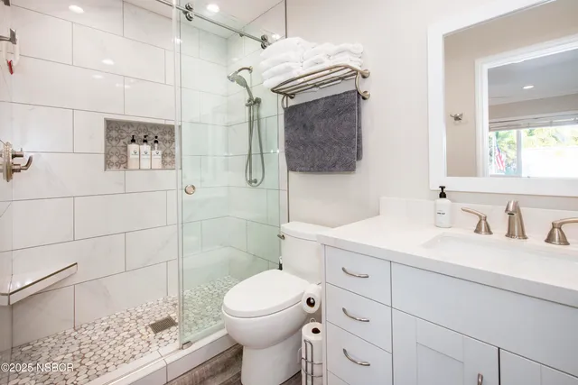 a bathroom with a sink a toilet and shower