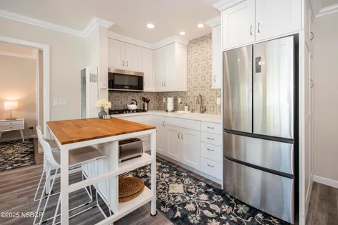 a kitchen with stainless steel appliances a refrigerator sink and microwave