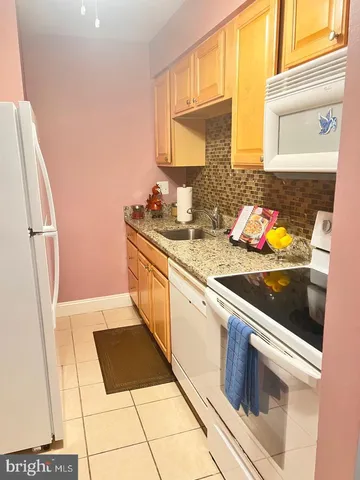 a kitchen with stainless steel appliances a stove a sink and a refrigerator