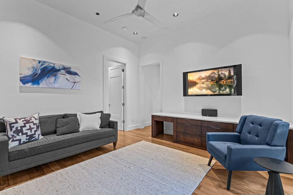 1905 Paisano Road Austin, TX 78746 - Photo 31 of 40 Hardwood floors and crisp white walls elevate this inviting and well-lit living space.