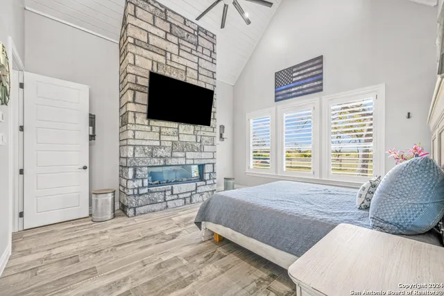 a spacious bedroom with a bed a flat screen tv and balcony view