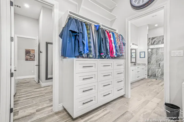 a view of walk in closet with clothes and shoes