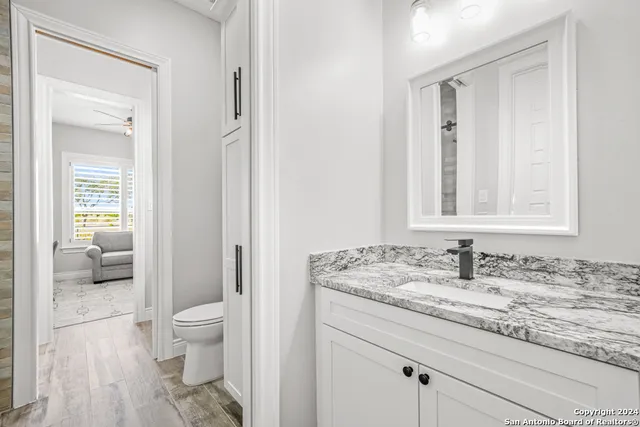 a bathroom with a granite countertop sink toilet and shower