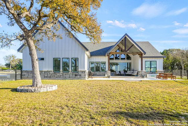 a front view of a house with swimming pool and porch with furniture