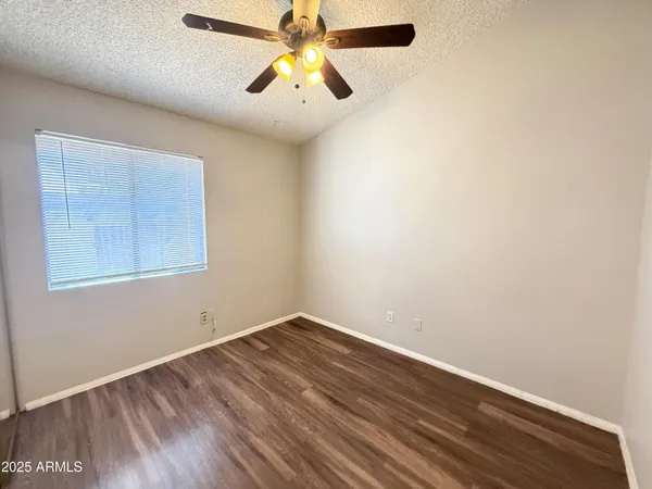 an empty room with a window and a ceiling fan