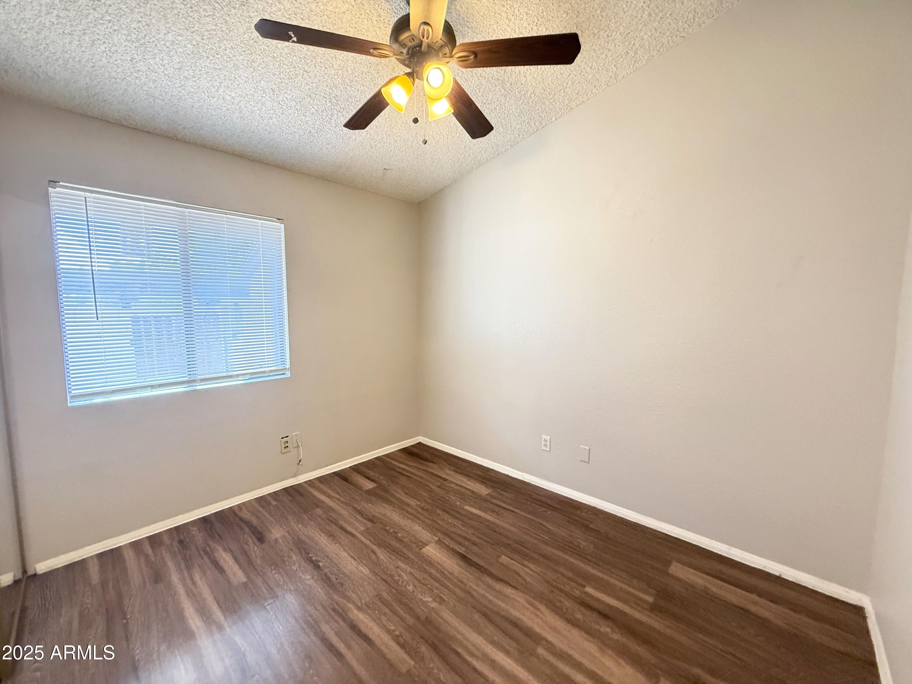 170 East Guadalupe Road, Unit 130 Gilbert, AZ 85234 - Photo 11 of 18 an empty room with a window and a ceiling fan