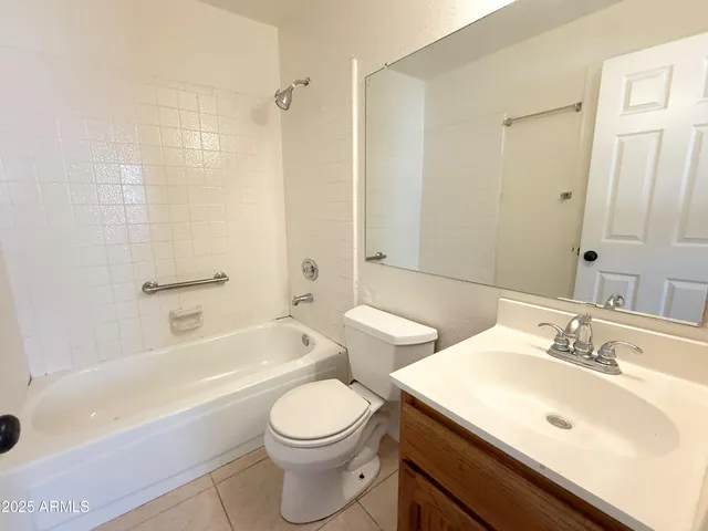 a bathroom with a bathtub shower sink mirror vanity and toilet