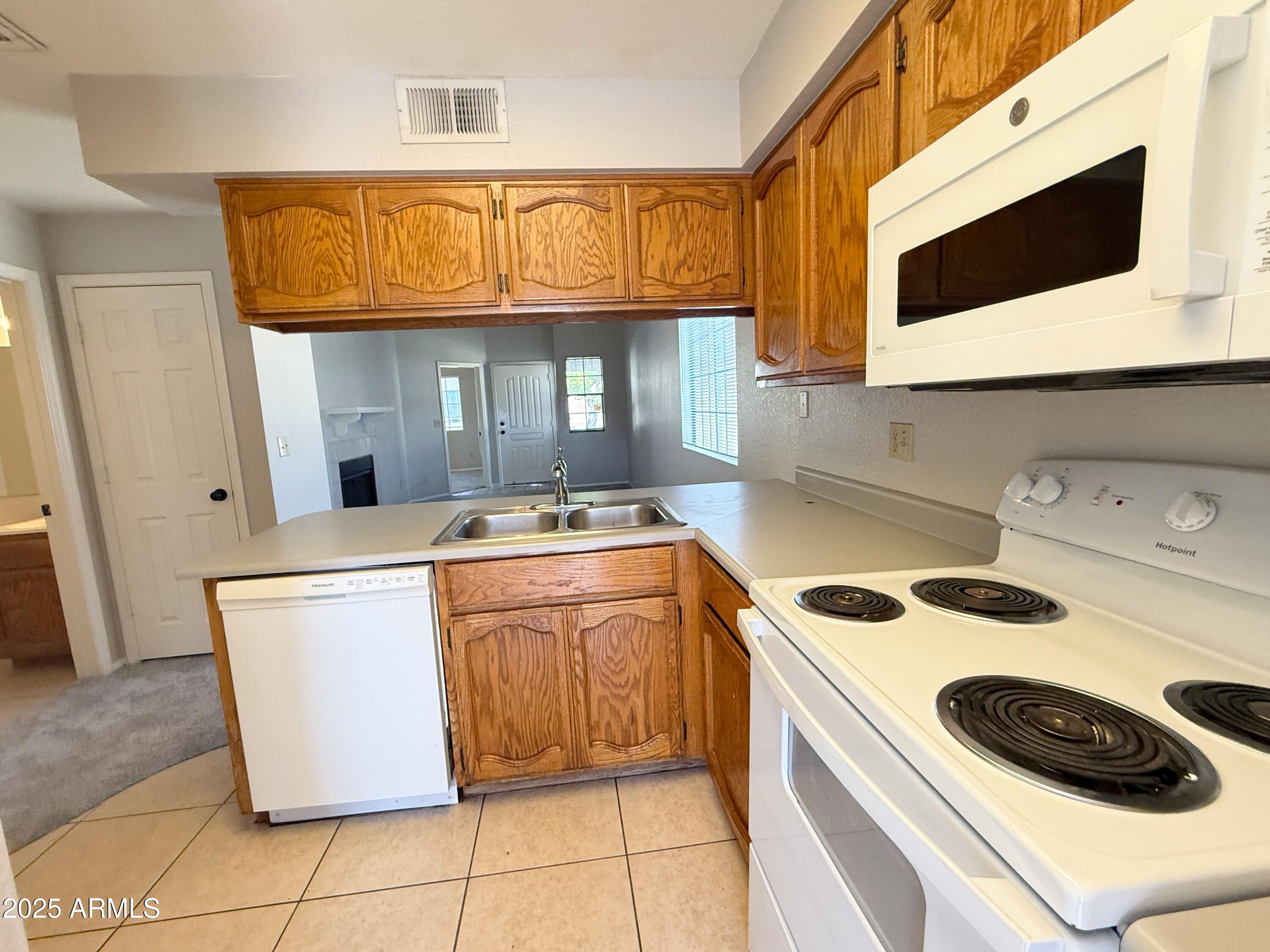 170 East Guadalupe Road, Unit 130 Gilbert, AZ 85234 - Photo 7 of 18 a kitchen with a stove and a microwave
