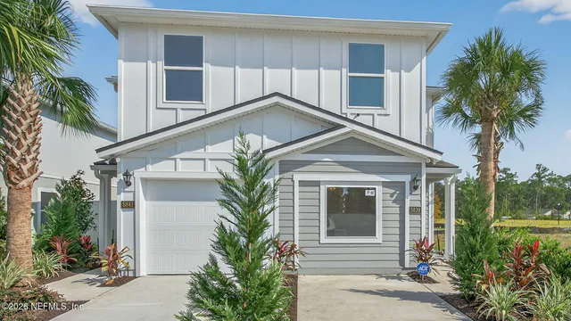 a front view of a house with a yard and potted plants
