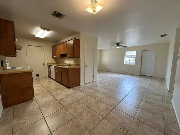 a kitchen with stainless steel appliances a sink a stove a microwave a counter top space and cabinets
