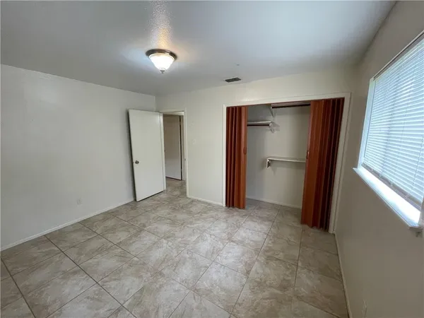 an empty room with closet and a window