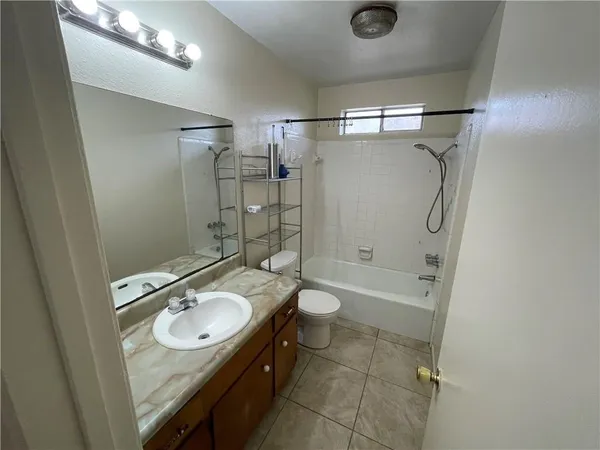 a bathroom with a sink a toilet a mirror and shower