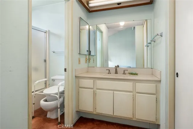 a bathroom with a toilet a sink and mirror