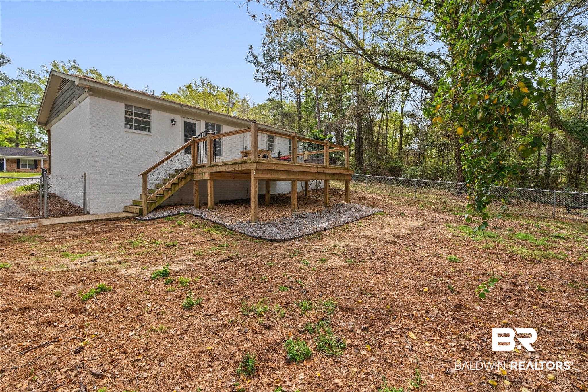 1849 Ranch House Drive Semmes, AL 36575 - Photo 21 of 23 Back of property featuring a fenced backyard, a gate, a wooden deck, and brick siding