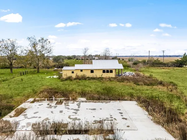 a backyard of a house with table and chairs