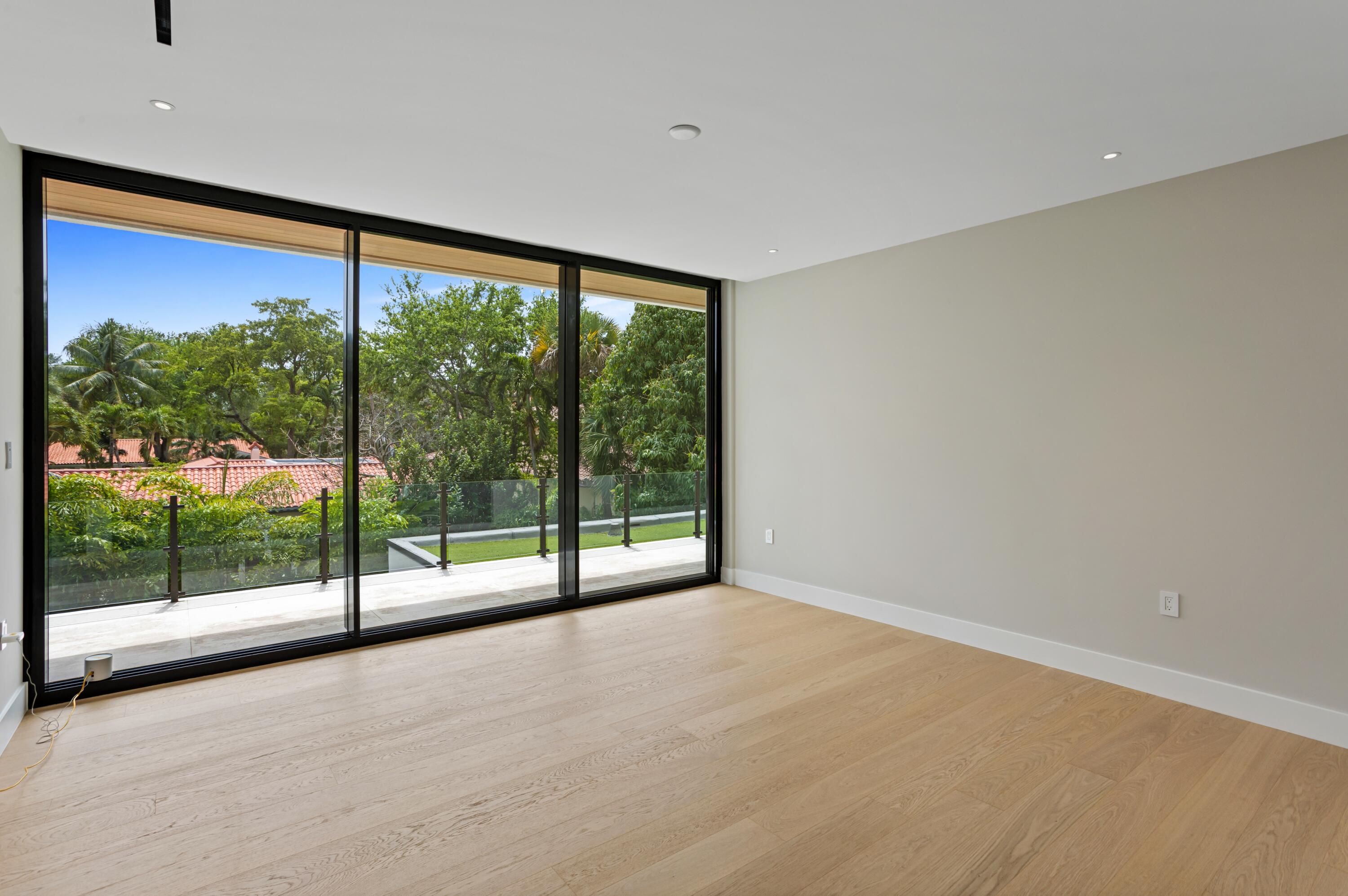 754 Oleander Street Boca Raton, FL 33486 - Photo 29 of 41 a view of an empty room with wooden floor and a floor to ceiling window