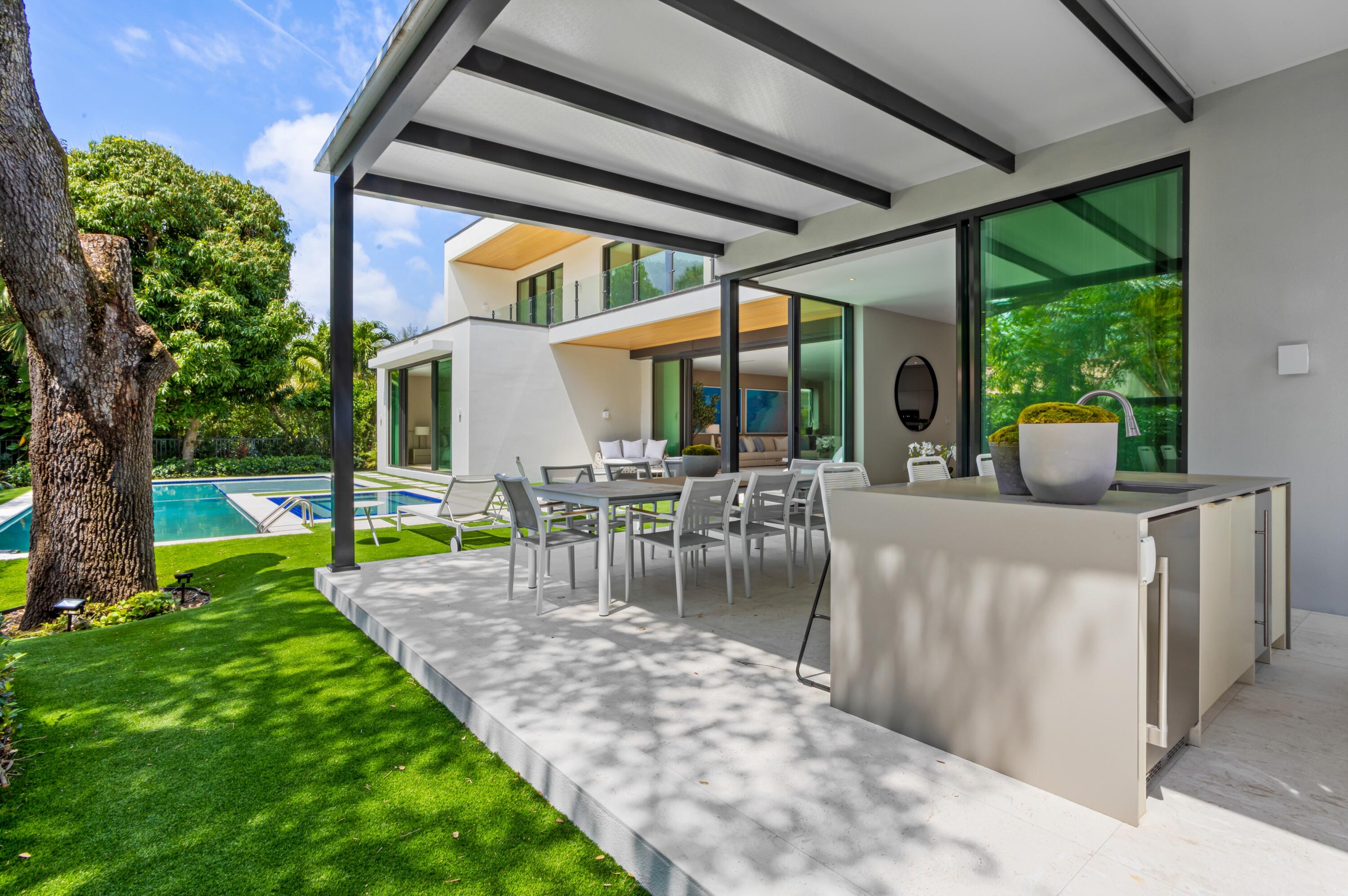 754 Oleander Street Boca Raton, FL 33486 - Photo 35 of 41 a view of a patio with table and chairs potted plants and large tree