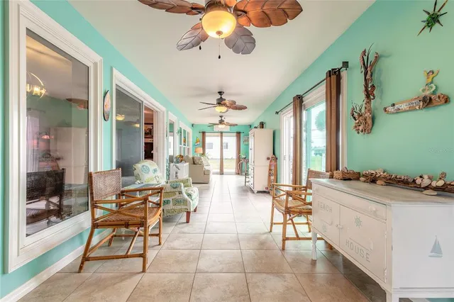 a living room with furniture a chandelier and a large window