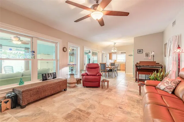 a living room with furniture ceiling fan and a large window