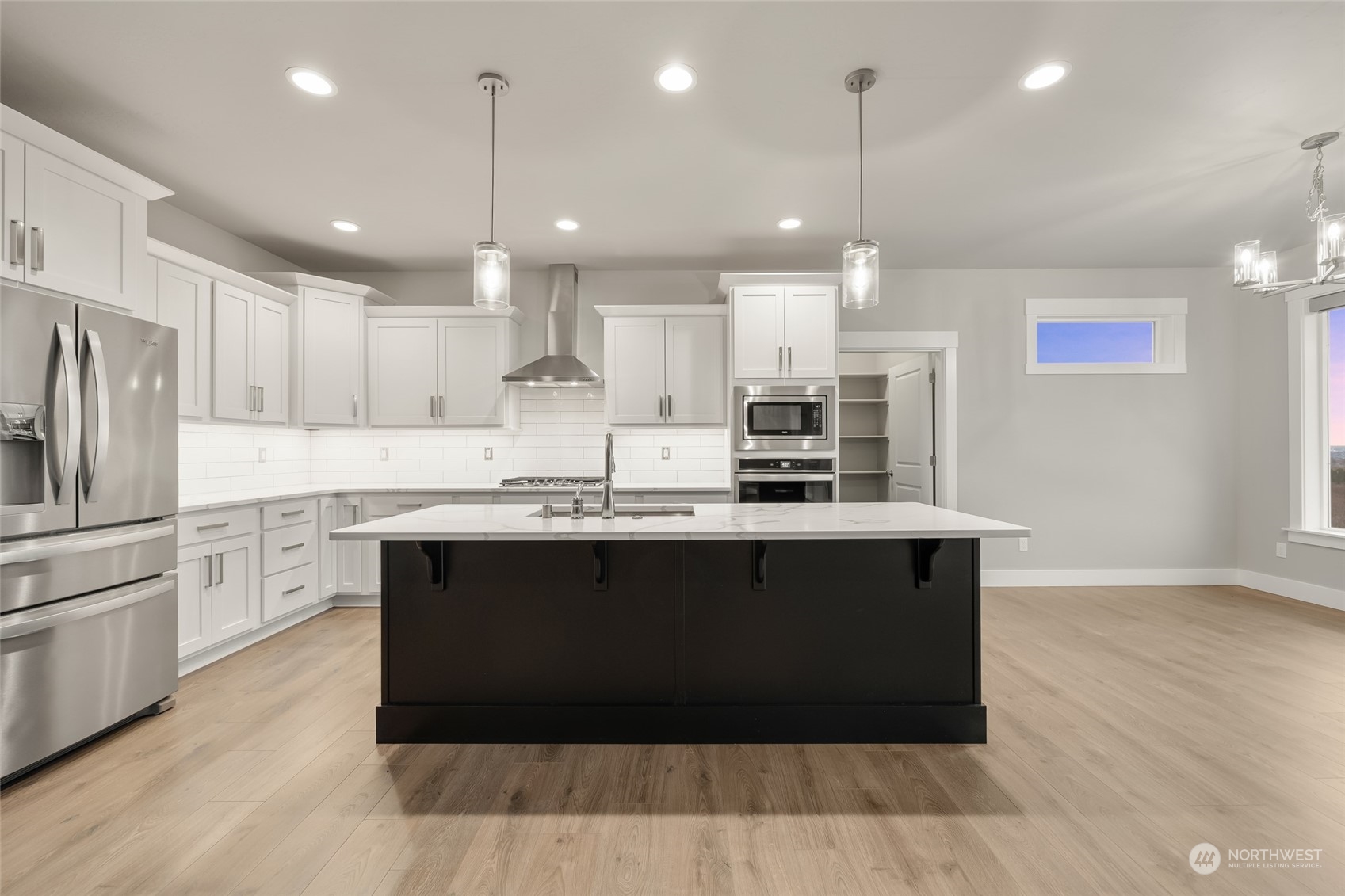 5307 South Kent Street Kennewick, WA 99337 - Photo 23 of 40 a large kitchen with stainless steel appliances granite countertop a stove a refrigerator a sink dishwasher and a oven with wooden floor