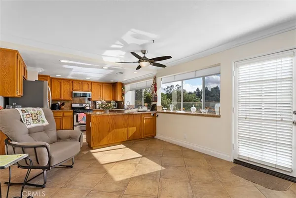 a living room with stainless steel appliances kitchen island granite countertop furniture and a large window