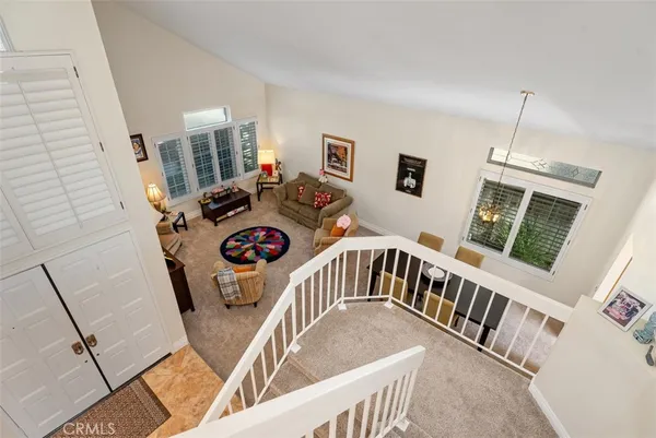 a view of a livingroom with furniture wooden floor windows and a chandelier