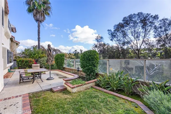 a view of a backyard with plants & palm tree
