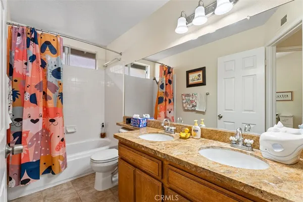 a bathroom with a granite countertop double vanity sink mirror and shower