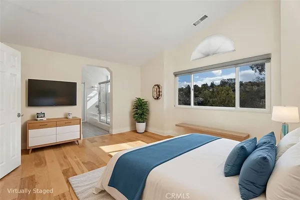 a bedroom with a bed and a flat screen tv