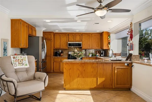 a kitchen with stainless steel appliances granite countertop a refrigerator a oven a stove and a dining table with wooden floor