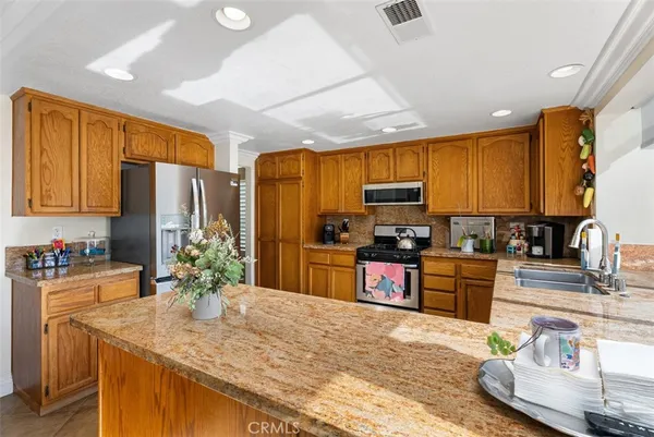 a kitchen with granite countertop a sink stainless steel appliances and cabinets