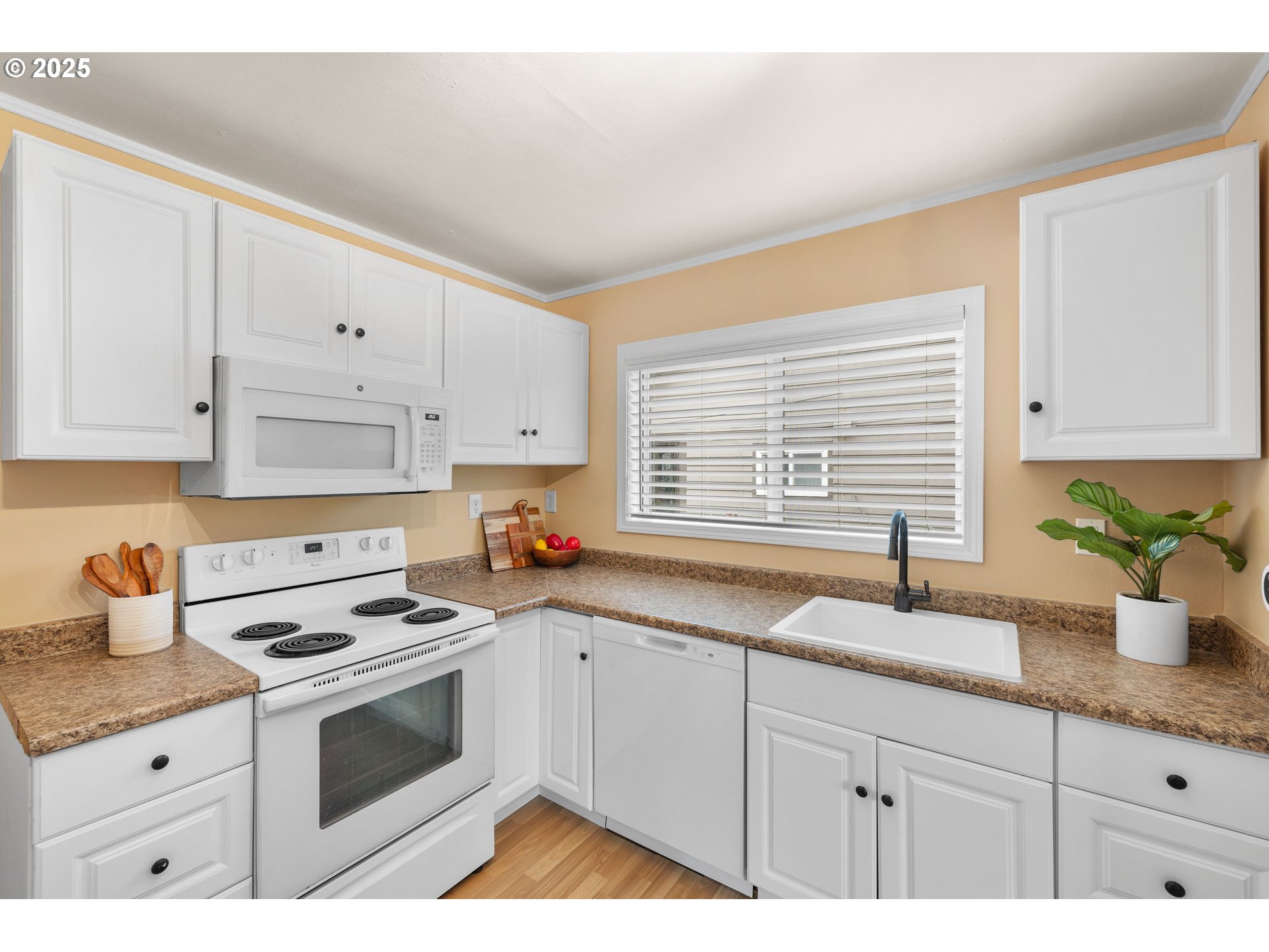 7643 Southeast Market Street Portland, OR 97215 - Photo 5 of 34 a kitchen with granite countertop a sink white cabinets and white appliances