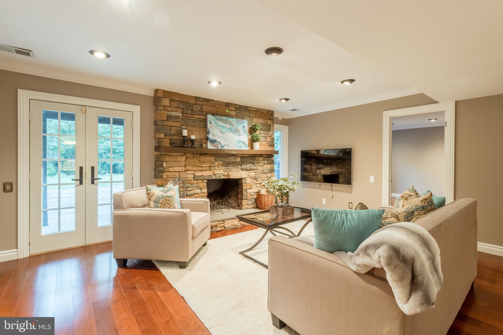 5402 Kennett Pike Wilmington, DE 19807 - Photo 53 of 81 a living room with furniture a flat screen tv and a fireplace