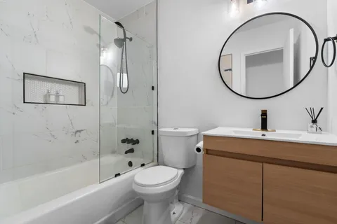 a bathroom with a sink a toilet and a mirror