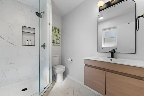 a bathroom with a sink a toilet and shower