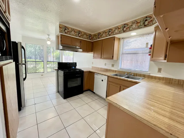 a kitchen with stainless steel appliances a sink and a refrigerator