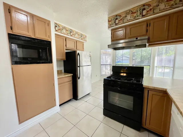 a kitchen with stainless steel appliances granite countertop a stove microwave and refrigerator