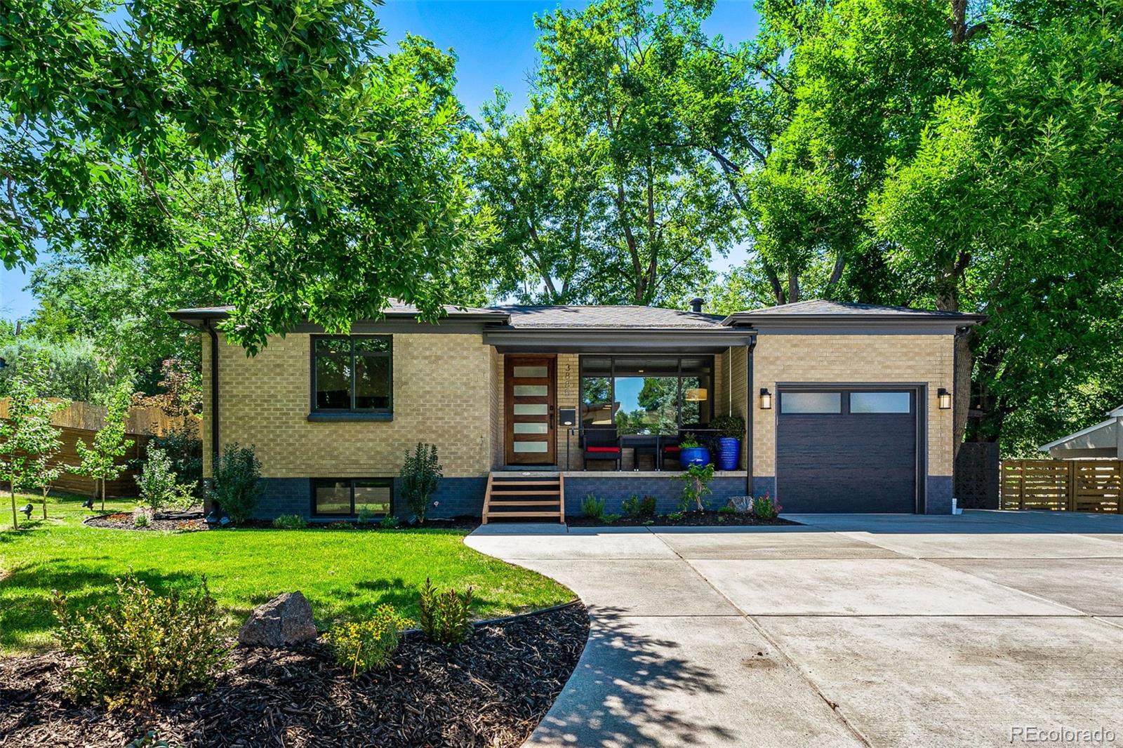 a front view of a house with a garden and plants