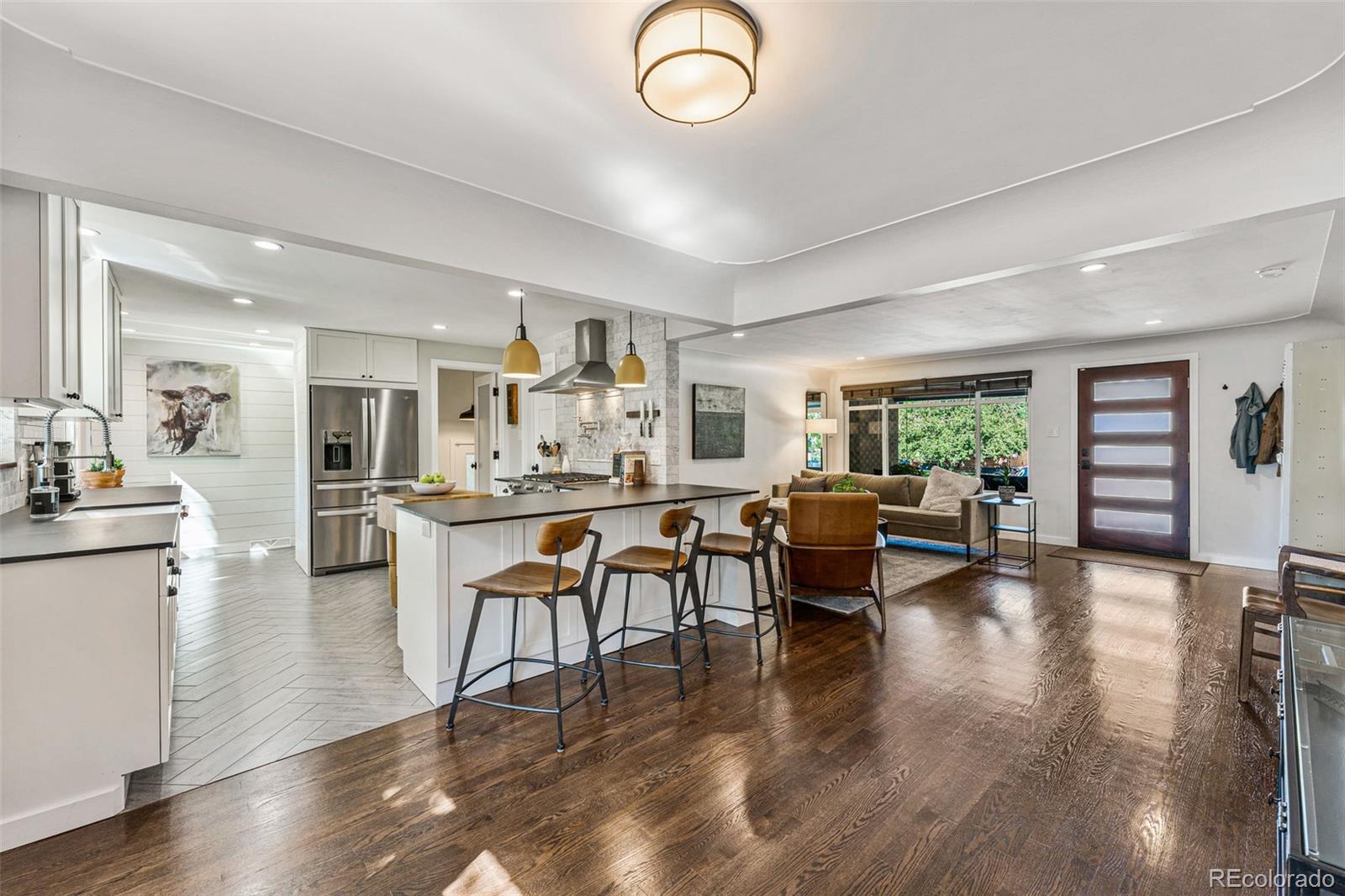 3885 Cody Street Wheat Ridge, CO 80033 - Photo 12 of 40 a living room with furniture kitchen view and a wooden floor