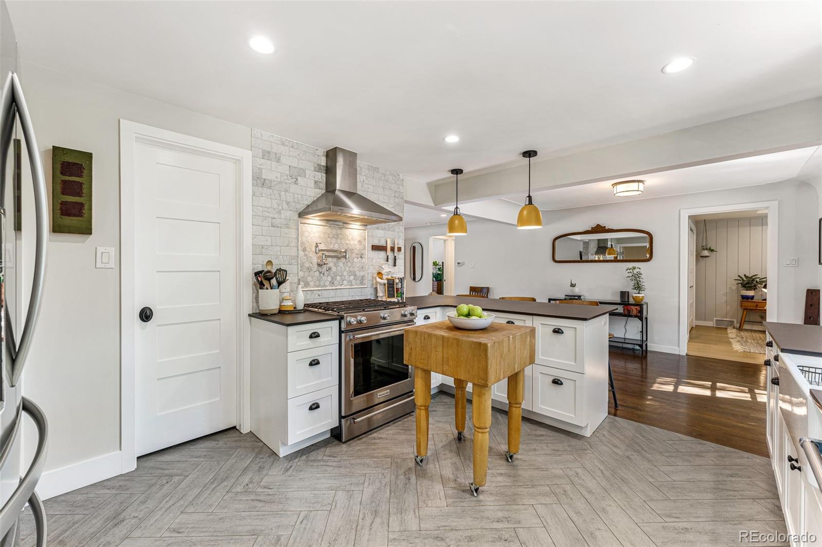 3885 Cody Street Wheat Ridge, CO 80033 - Photo 15 of 40 a kitchen with a sink cabinets and wooden floor