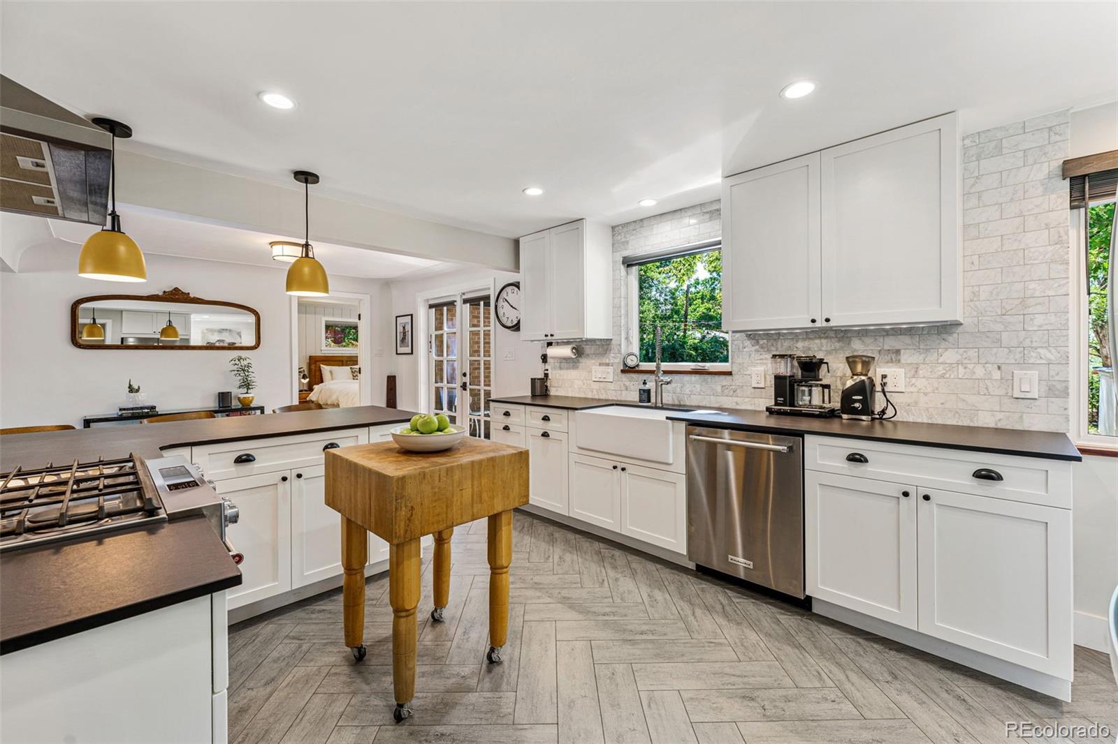 3885 Cody Street Wheat Ridge, CO 80033 - Photo 16 of 40 a kitchen with stainless steel appliances granite countertop a sink counter space cabinets and a window