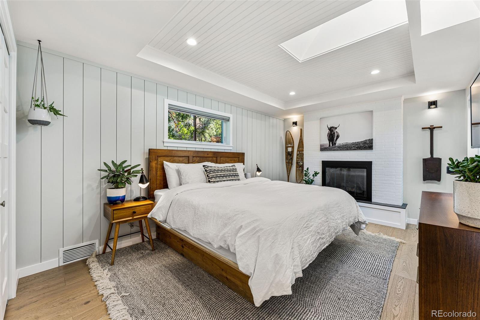 3885 Cody Street Wheat Ridge, CO 80033 - Photo 18 of 40 a bedroom with a bed and a fireplace