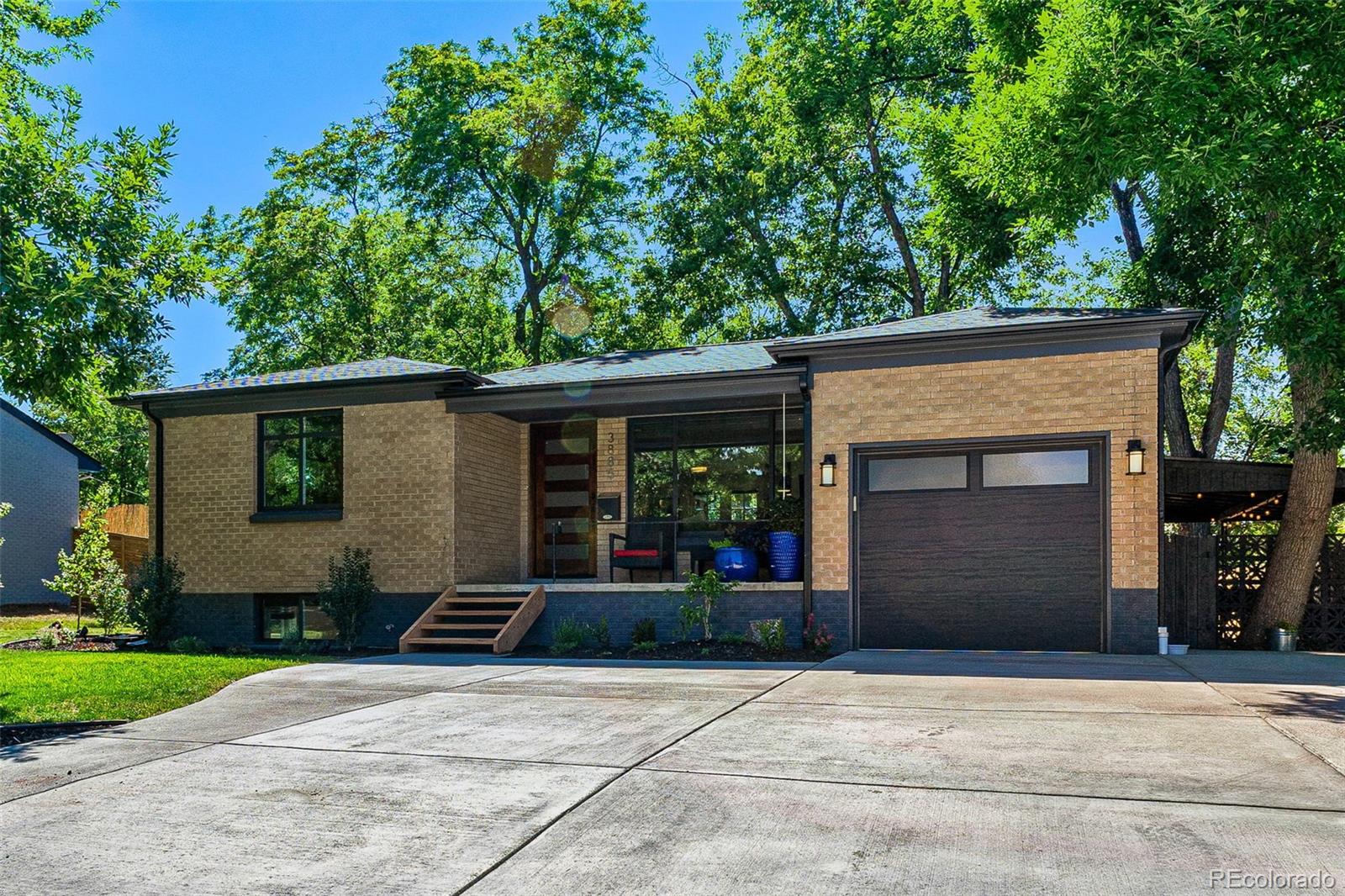 3885 Cody Street Wheat Ridge, CO 80033 - Photo 2 of 40 a front view of a house with a yard and a garage