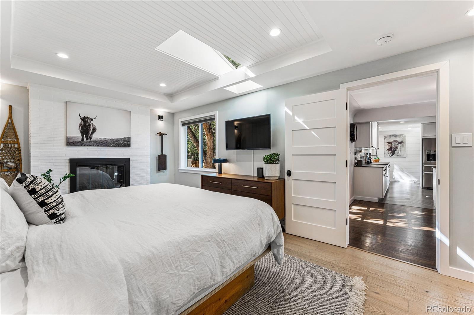 3885 Cody Street Wheat Ridge, CO 80033 - Photo 21 of 40 a bedroom with a large bed and a flat screen tv