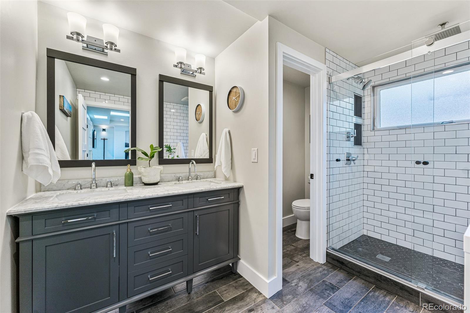 3885 Cody Street Wheat Ridge, CO 80033 - Photo 22 of 40 a spacious bathroom with a granite countertop sink mirror and a shower